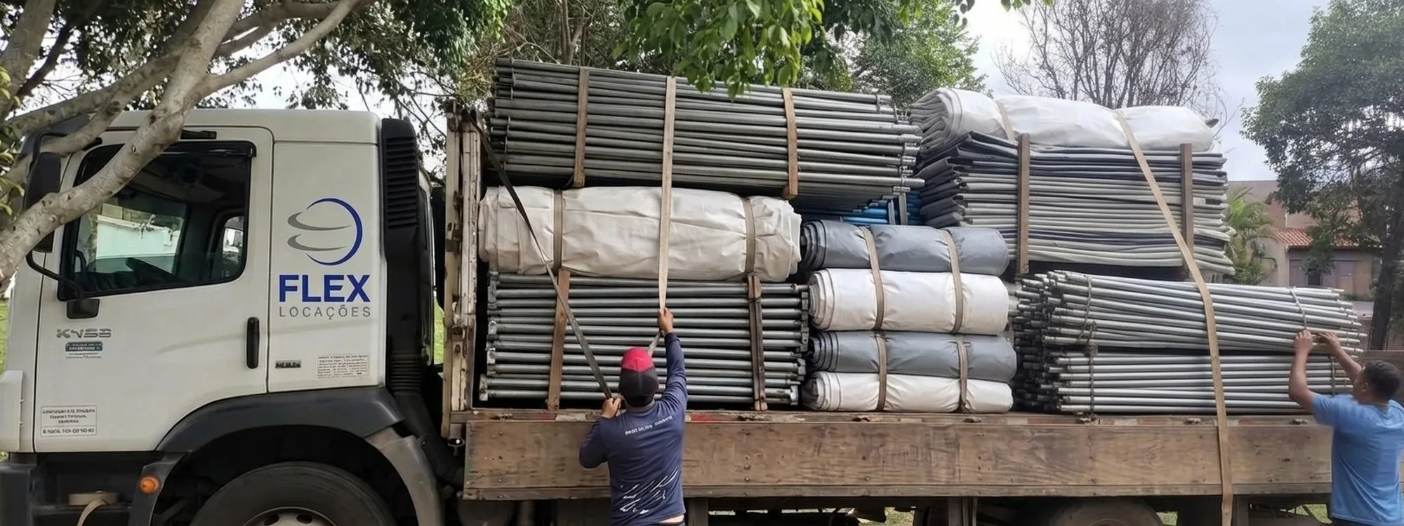 Equipe da Flex carregando estruturas no caminhão da frota própria
