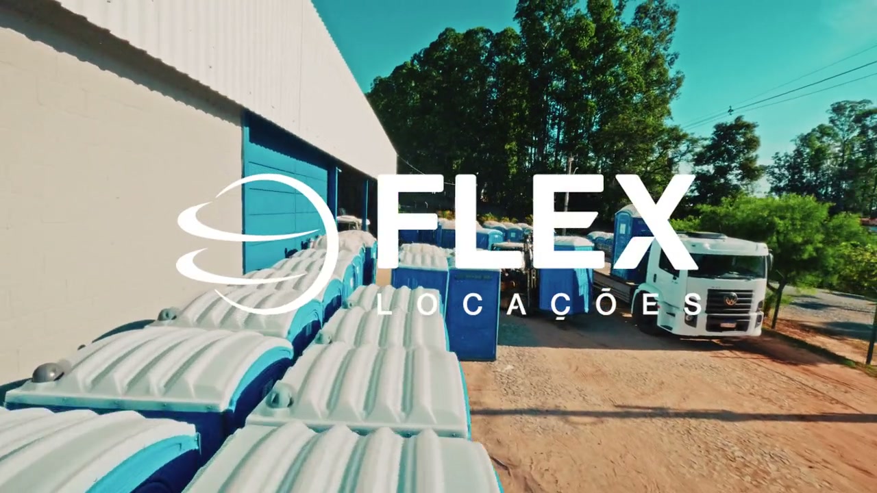 Pátio da Flex Locações em Divinópolis, com banheiros químicos enfileirados e o galpão ao fundo